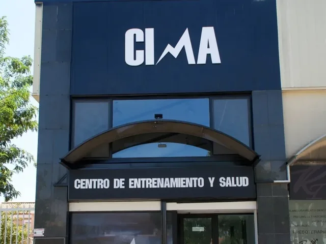 Fachada de CIMA, Centro de Entrenamiento y Salud: letras y banda con el nombre en PVC blanco sobre panel azul, con el vinilo de la marca en el escaparate.